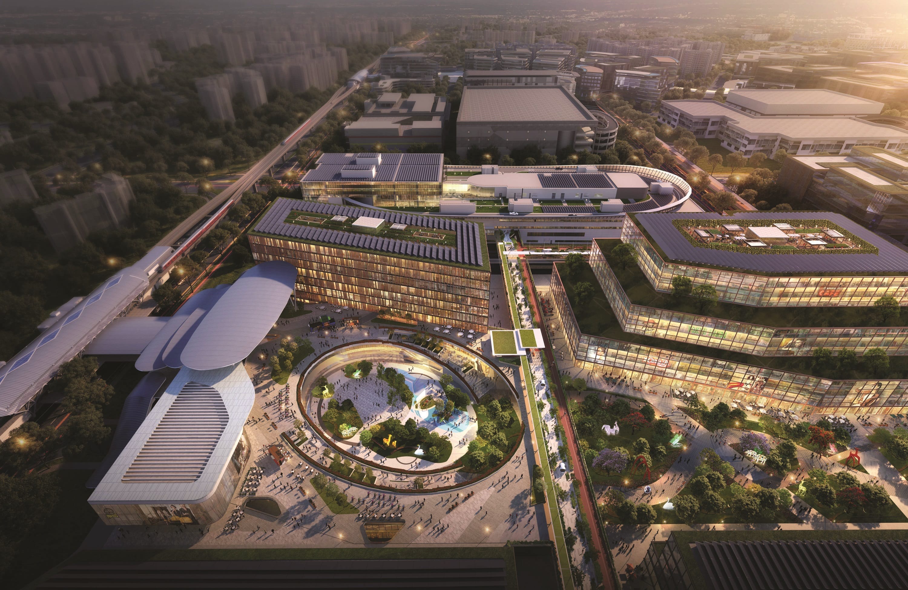Aerial view of a modern urban development with buildings, gardens, and pedestrian areas at sunset.